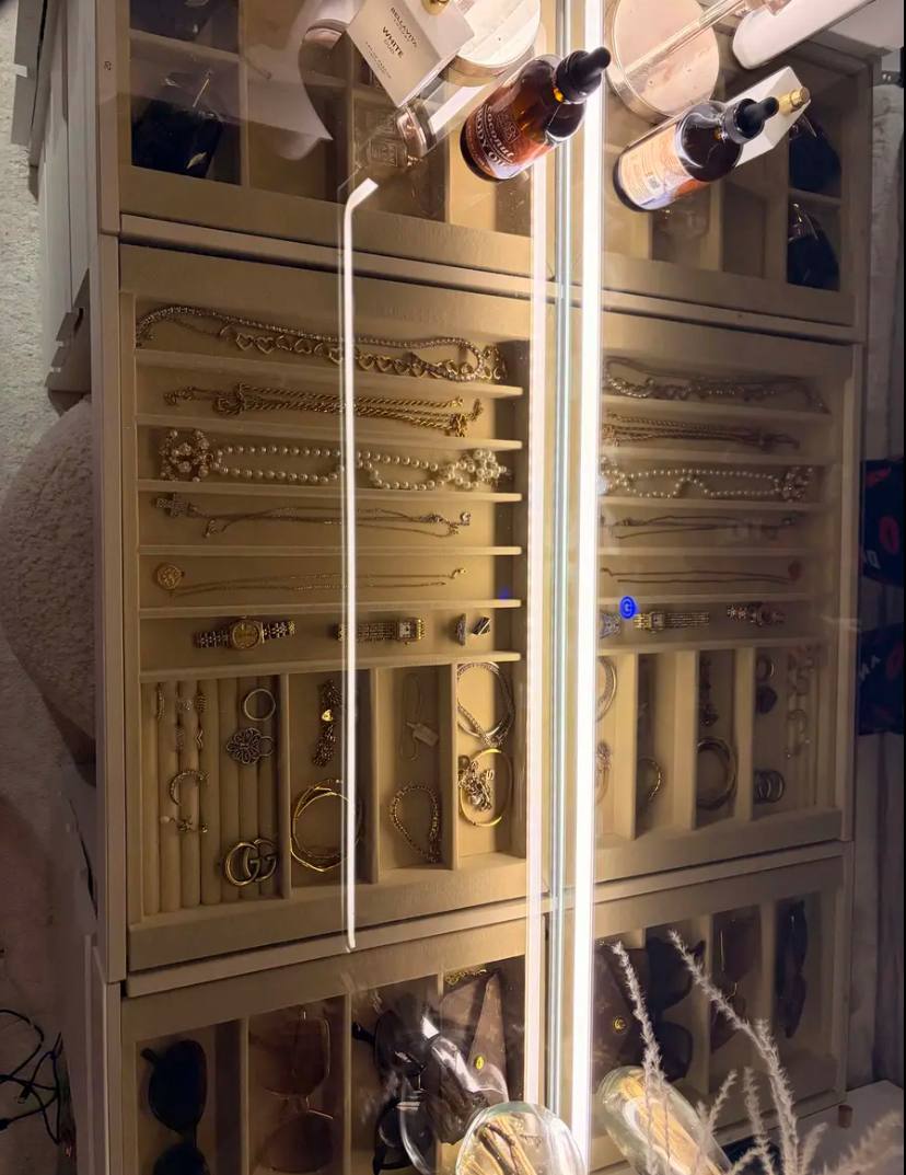 Kaptafel ingericht met sieraden en parfums op het glazen blad